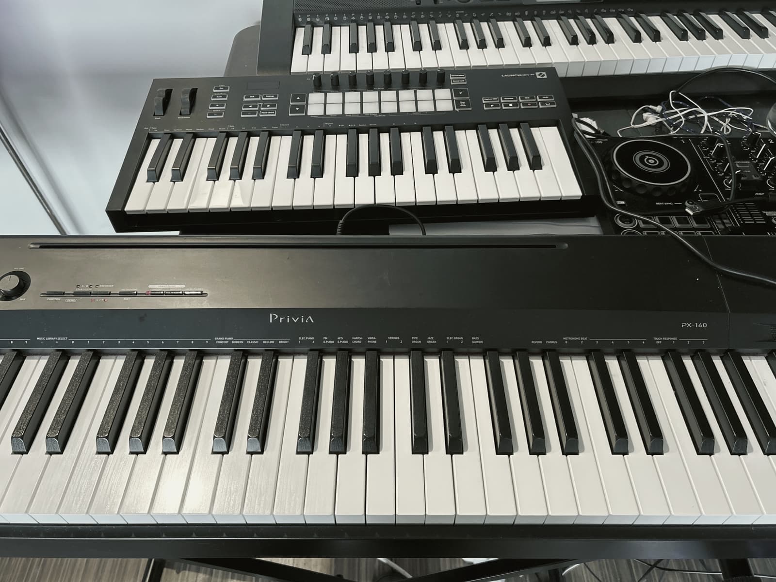 A digital piano stacked with a DJ controller