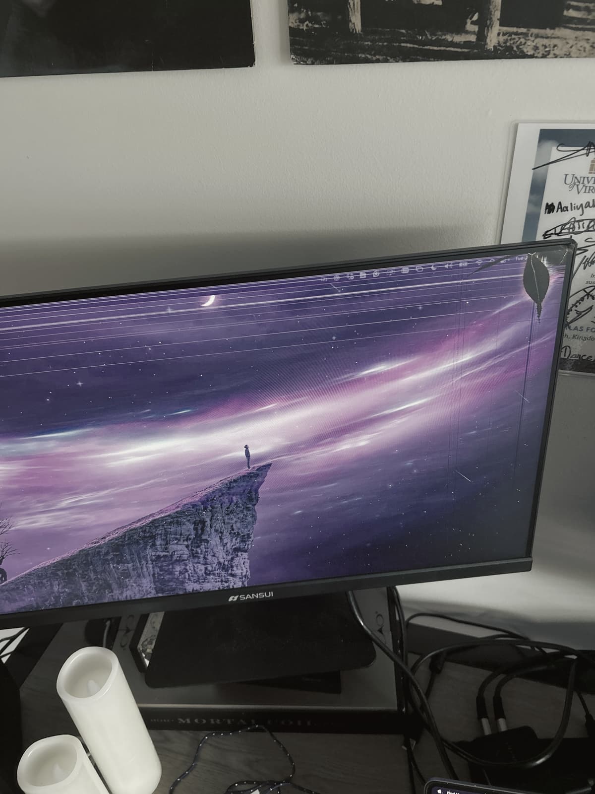 A monitor glowing beside flameless candles